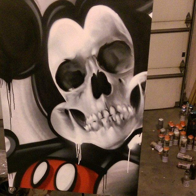 Canvas of a round-eared cartoon character rendered as a skull, black and white with red shorts and paint drips