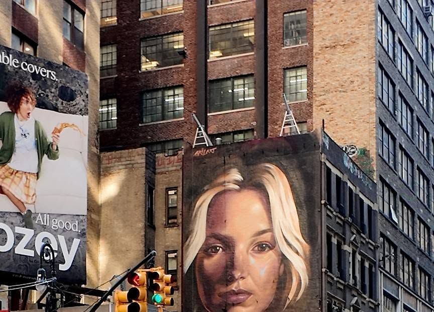 Finished portrait of a blonde woman filling a four-story brick side wall above a Manhattan street