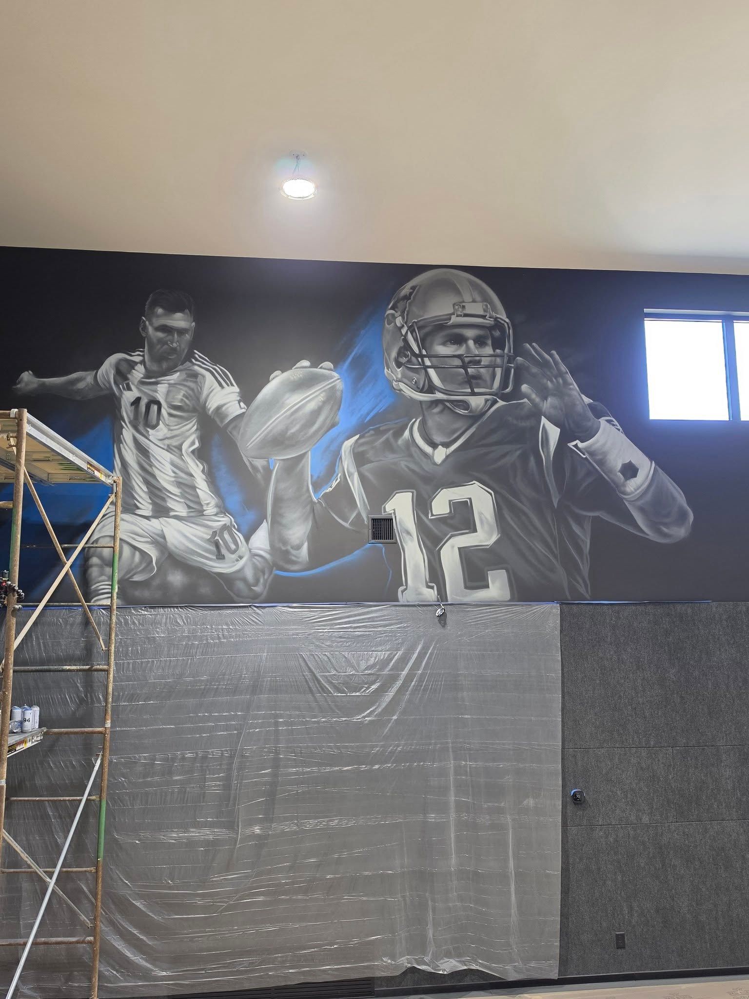 Painted footballer in a number 10 shirt beside a quarterback in a number 12 jersey, blue sweeps behind them