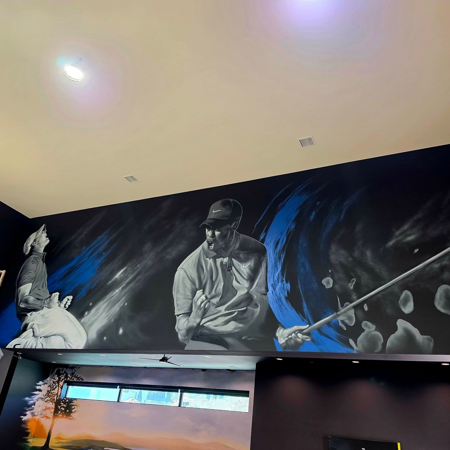Grayscale portrait of a golfer mid-swing painted across a charcoal wall above a home golf simulator