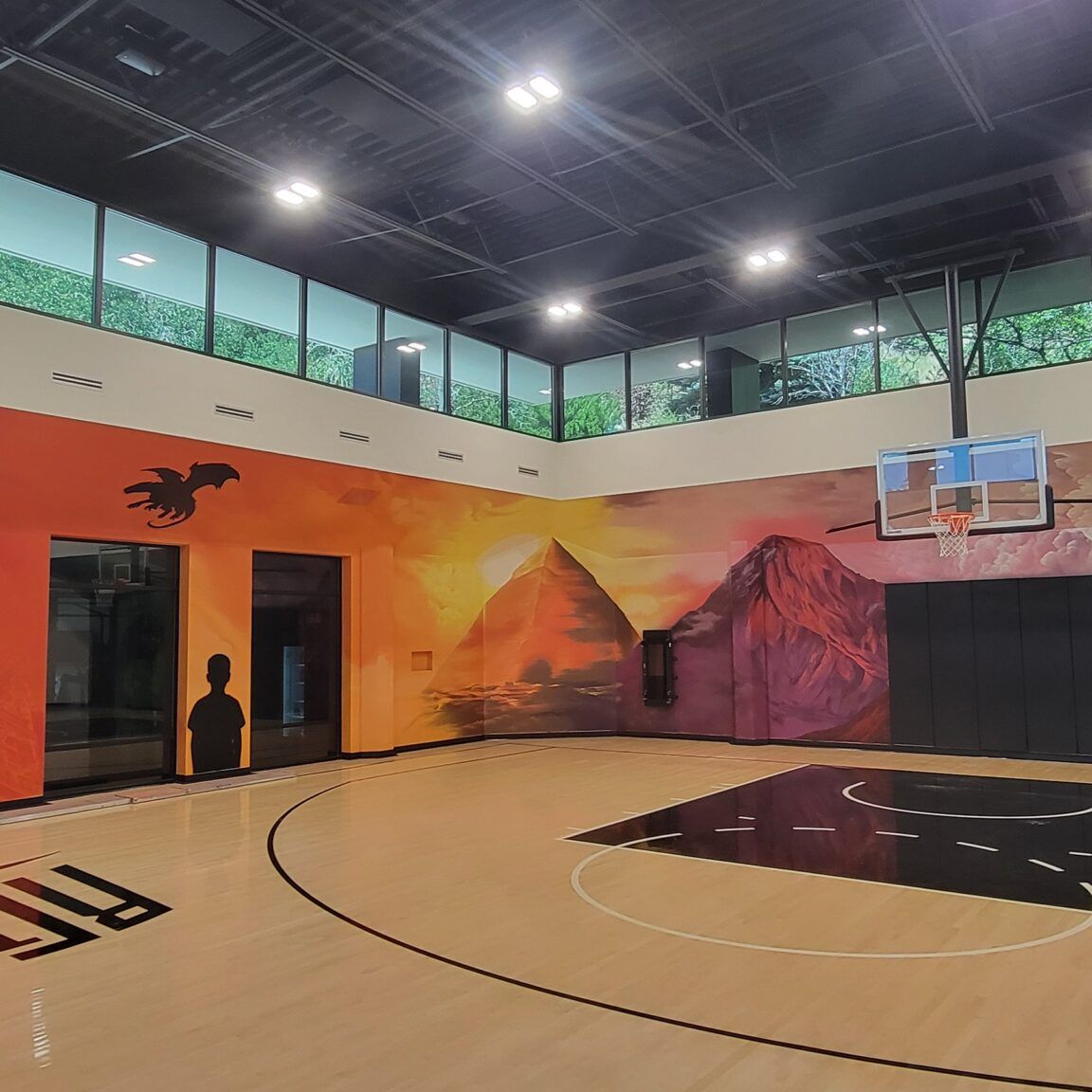 Shae Petersen (SRIL ART) painting custom narrative mural for Rudy Gobert's private court
