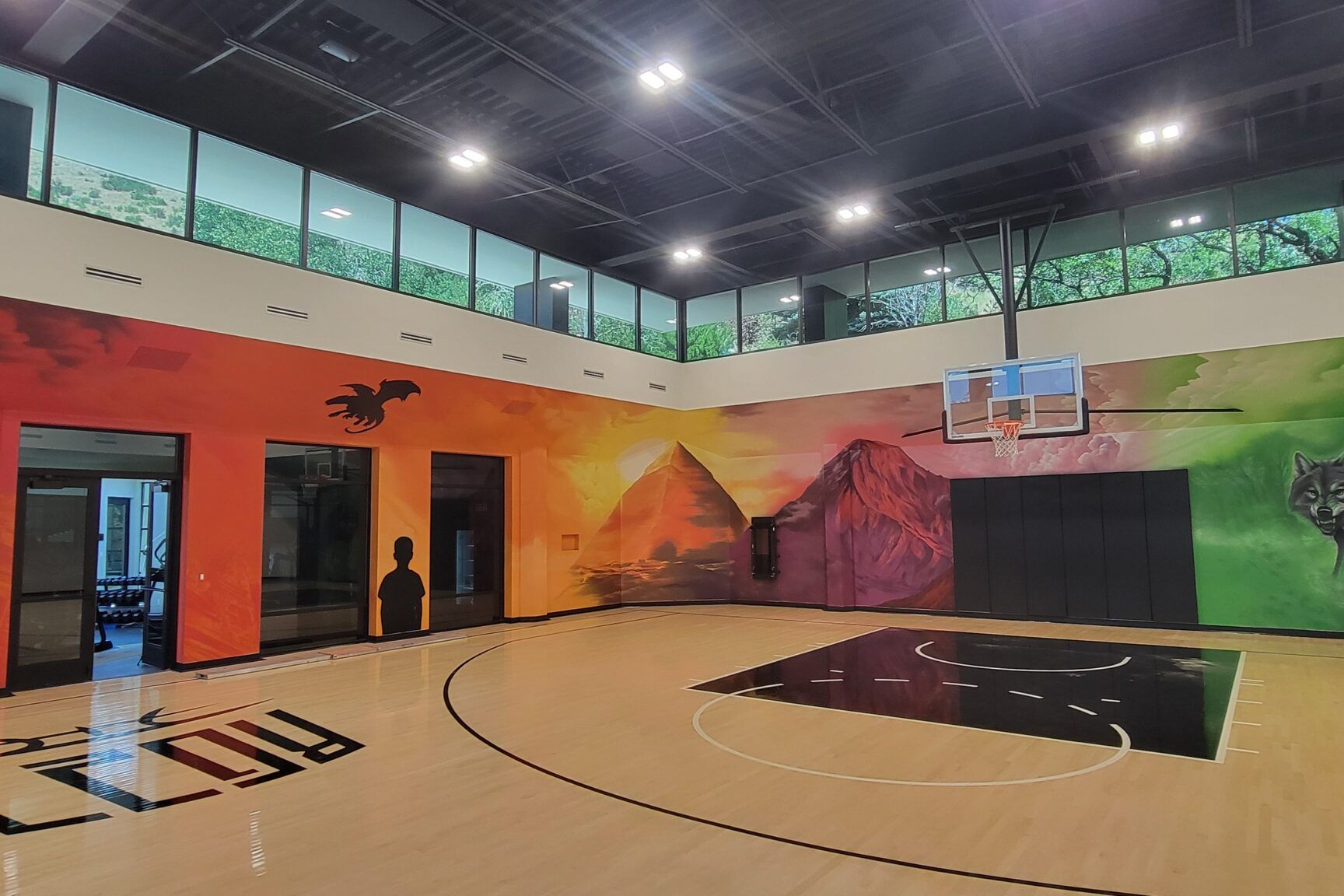 Shae Petersen (SRIL ART) painting custom narrative mural for Rudy Gobert's private court