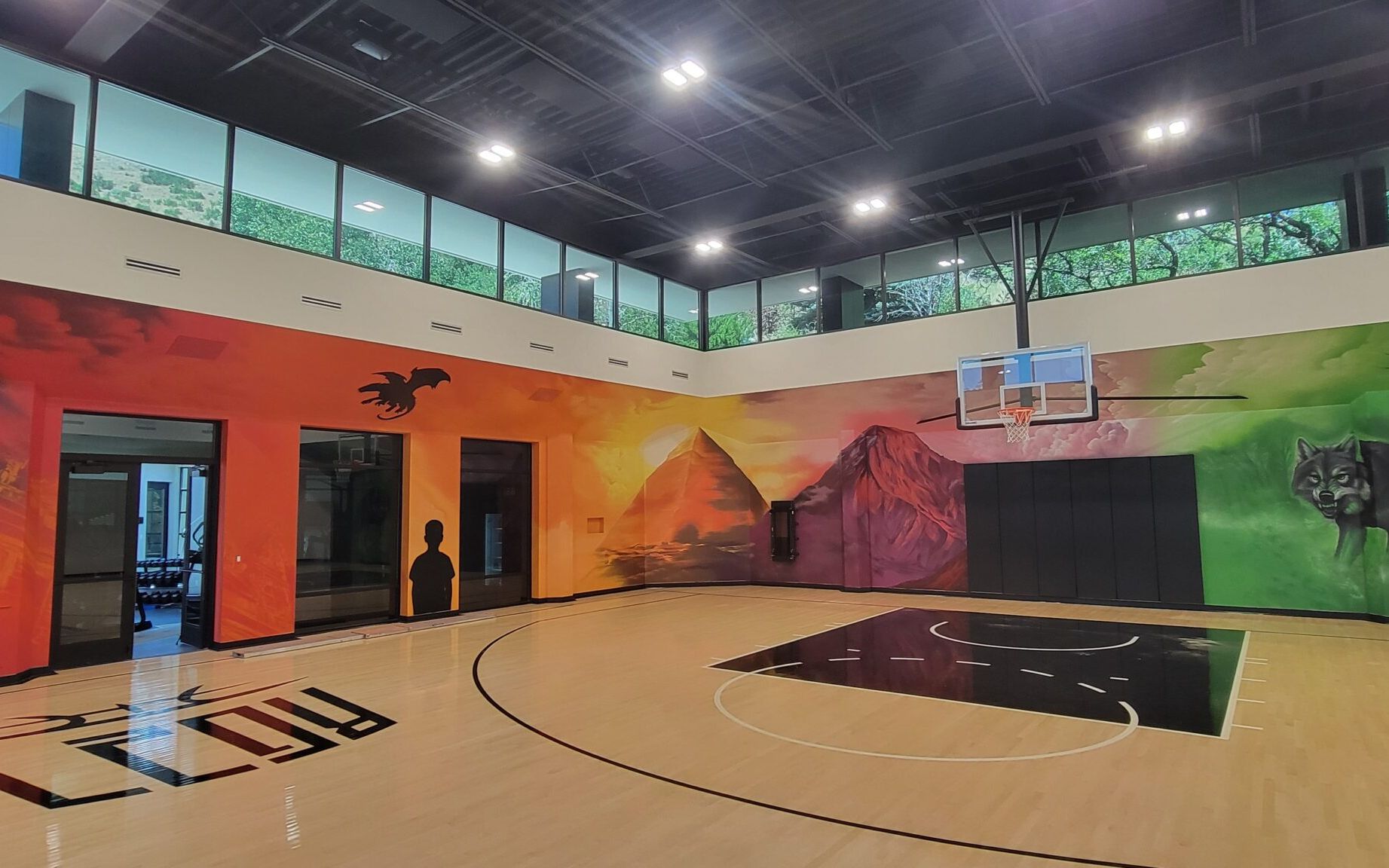 Shae Petersen (SRIL ART) painting custom narrative mural for Rudy Gobert's private court