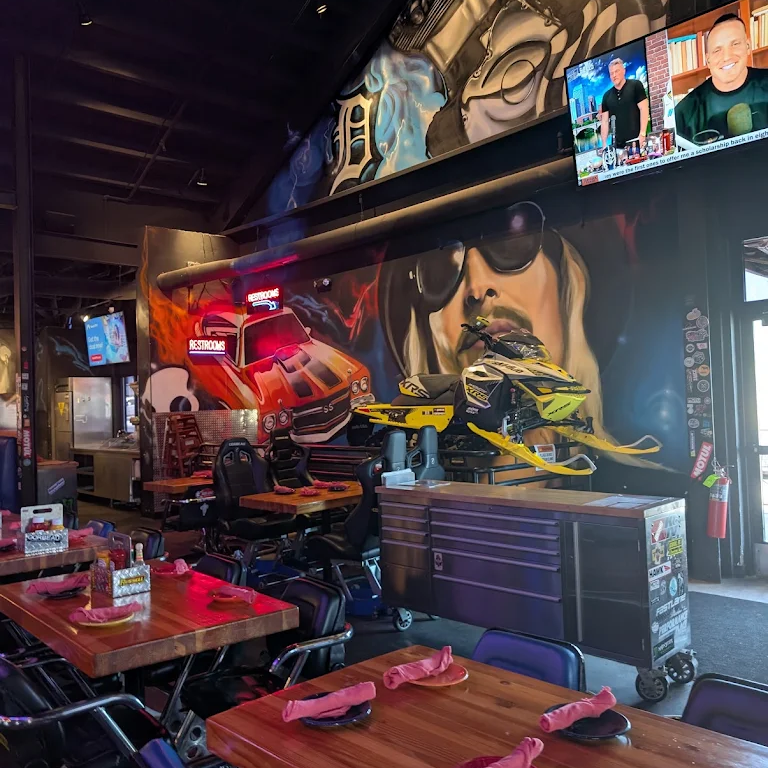 Kid Rock portrait mural with hot rod and snowmobile graphics inside a Park City restaurant