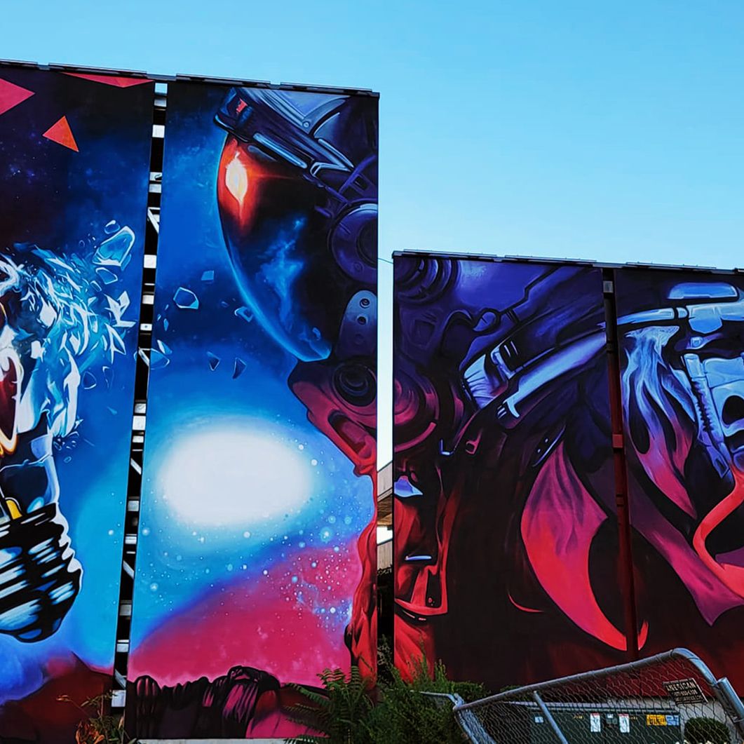 Astronaut gripping an exploding lightbulb, painted across two faces of a downtown Salt Lake City parking garage