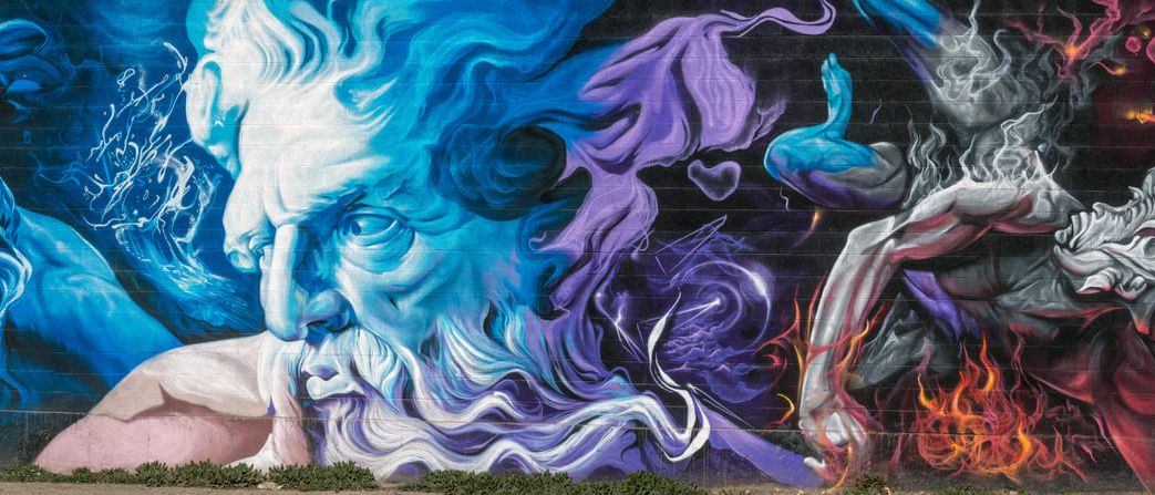 A long cinder-block wall painted end to end with Greek gods in blue, purple and fire