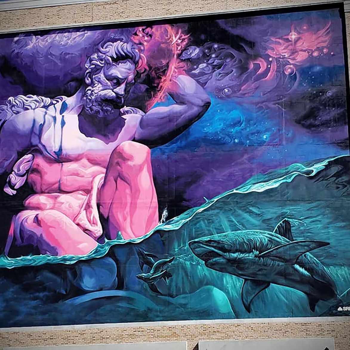 Bearded god in pink and purple reaching into a red nebula above a turquoise sea with sharks, painted across a building facade