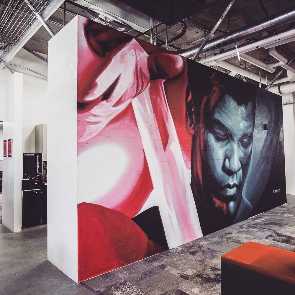 Red drapery and a blue-toned portrait painted across a freestanding office wall