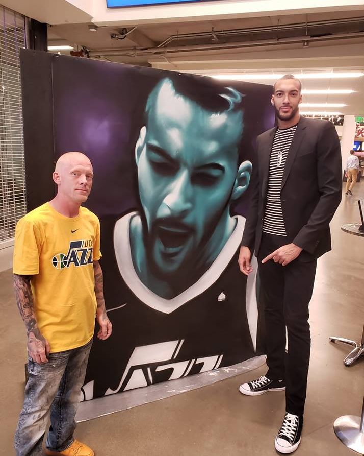 Shae Petersen with Utah Jazz center Rudy Gobert beside SRIL ART's mural portrait of him